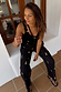 Black Shell Elissa Trousers with a gold seashell print and wide-leg fit, styled for a vacation look.