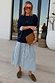 Navy Knit Jumper Dress featuring a blue stripe cotton skirt, styled with a brown clutch and oversized sunglasses.