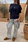 Navy knit dress with a striped cotton skirt, styled as a multi-wear layer over light wash jeans.
