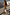 Thumbnail for Silver Metallic Ribbed Midi Dress with a side slit, walking through a sunny outdoor courtyard.