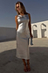 Silver Metallic Ribbed Midi Dress with a sleeveless silhouette, worn by a model in a sunlit outdoor setting.