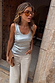 Silver Metallic Scoop Neck Tank in a soft stretch ribbed fabric, paired with ecru jeans and a leopard print clutch.