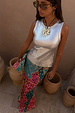 Metallic silver ribbed tank top styled with a colourful patterned skirt and sun necklace.