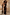 Thumbnail for Black & Gold Simona Sequin Maxi Dress in sheer mesh with a trailing scarf, styled on a model against a stone wall.