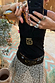 Deloris Mermaid Necklace with an engraved brass pendant on an adjustable leather cord, worn with a leopard skirt.