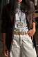 Deloris Mermaid Necklace featuring an engraved brass pendant on a black leather cord, styled over a brown blazer.