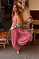 Pink Snake Balloon Trousers with snake and swirl motifs, styled with a patchwork top in a rustic textile market.
