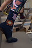Thumbnail for Navy Element cotton crew socks with sun and hand motifs, styled with patterned leggings on a Pilates reformer.