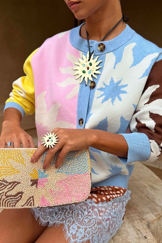 Soleil Hollie Cardigan featuring iconic pastel sun motifs and soft touch knit, styled with a beaded clutch.