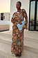 Star Fawn Aria Mesh Dress in brown with celestial star motifs and sheer flared sleeves, worn by a model with a blue clutch.