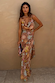 Star Fawn Sophie Dress in brown with sun and star motifs, featuring a draped neck, scarf, and clutch bag.