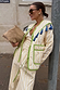 Butter Yellow Stripe Quilted Jacket with green trim and blue tassels, worn by a model in an outdoor street setting.