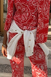 White Marley Shirt with gold studs on the sleeves, tied around the waist of a red bandana print outfit.