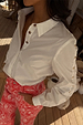 White cotton Marley Shirt with gold stud detailing on the sleeves, styled with red bandana jeans.