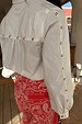 White cotton Marley Shirt with gold studs on the sleeve and back, worn with red bandana print jeans.