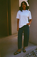 White cotton T-shirt with silver stud detailing at the neckline and a relaxed fit, styled with denim jeans.