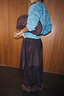 Thumbnail for Multi-wear Chocolate Suede Jaspre midi wrap skirt with a studded blue jumper and matching suede clutch against wood panels.