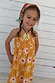 NFD Kids Yellow Cotton Sun Dress with an orange sun print and shirred bodice, worn by a young girl.