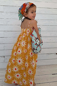 NFD Kids Yellow Cotton Maxi Sun Dress with a sun print and shirred bodice on a young girl.