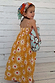 NFD Kids Yellow Cotton Maxi Sun Dress with a sun print and shirred bodice on a young girl.