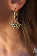 Gold-tone Deloris Sun Hoop Earrings featuring iconic sun motifs and semi-precious stones, worn on the ear.