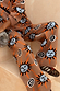 Thumbnail for Tan Sun Trousers in a stretch knit featuring sun and swirl motifs, styled as a co-ord with leopard trainers.