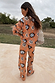 Tan Sun Trousers and matching knit jumper featuring Mediterranean-inspired sun motifs, viewed from behind.