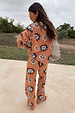 Tan Sun Trousers and matching knit jumper featuring Mediterranean-inspired sun motifs, viewed from behind.