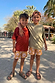 Boy's Yellow Sun Swim Shorts with a sun print and drawstring, worn by two children on a sunny vacation.