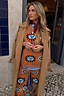 Thumbnail for Tan Sun Copenhagen Jumper featuring sun motifs, styled with matching trousers and a draped camel trench coat.
