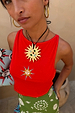 Orange Sun Twisted Strap Tank in ribbed jersey with an embroidered sun motif, gold necklace and green skirt.