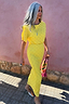 Yellow Sunshine Tilly midaxi dress in stretchy plisse with gold flecks, styled outdoors against a pink wall.