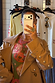 Tan Trench Coat with Gold Studs featuring gold dome hardware on the sleeves, styled over a colourful printed top.