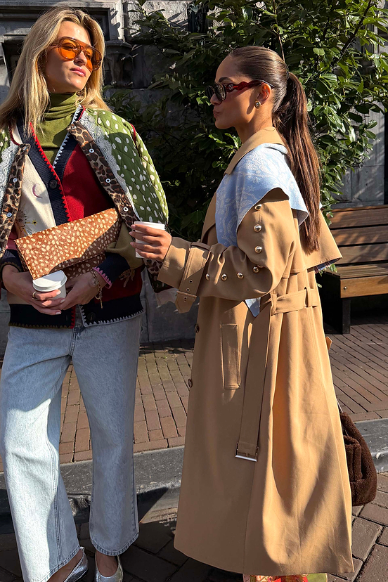 Tan Trench Coat with Gold Studs along the sleeves, a transeasonal statement staple for classic London looks.