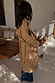 Tan Trench Coat with gold studs on the sleeve and a waist belt, worn by a model who is 5ft7” and wears size M.