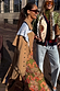Tan trench coat featuring gold studs on the sleeves, styled as a statement staple for a London street look.