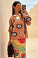 Thumbnail for Tan Sun Copenhagen Jumper in a tan knit with hand-painted sun motifs, styled with a colourful patterned skirt.