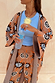 Thumbnail for Tan Sun Cardigan with Mediterranean sun motifs and wide sleeves, styled with matching knit trousers.