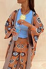 Tan Sun Cardigan with Mediterranean sun motifs and wide sleeves, styled with matching knit trousers.