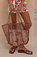 Tan mesh tote bag with leather shoulder straps and a removable abstract soleil print pouch in a summer setting.