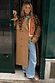 Tan Trench Coat with gold studs and leopard scarf, a statement staple styled over a green knit and wide-leg jeans.