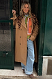 Tan Trench Coat with gold studs and leopard scarf, a statement staple styled over a green knit and wide-leg jeans.
