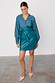 Teal vegan leather Mini Jaspre wrap skirt styled with a matching shirt and pink pointed-toe heels.