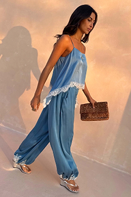 Blue Lace Balloon Trousers in a washed blue satin with delicate lace trims and elasticated ankles on a walking model.