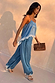 Blue Lace Balloon Trousers in a washed blue satin with delicate lace trims and elasticated ankles on a walking model.