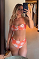 Orange Soleil sun print bikini top featuring a twist front, styled with high-waisted bottoms in a mirror selfie.