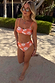 Orange Sun Bandeau Bikini Top with a Soleil print and twist front, styled on a model for a vacation look.