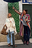 Thumbnail for Cream Western Knitted Cape featuring blue western embroidery and a fringed hem, styled with a leopard print bag.