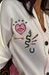 Cream Western Martha Cardigan detail with embroidered motifs and multi-coloured criss-cross stitching.