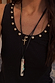 Deloris Whistle Necklace with a polished silver-tone pendant and colourful gemstones on a layered black leather cord.